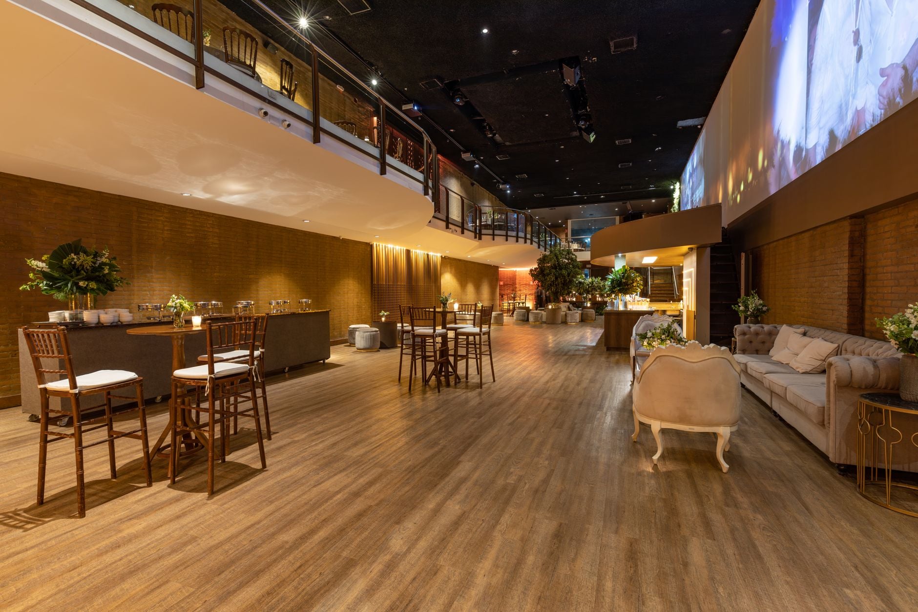 Ruimtelijke moderne locatie met elegante zitplaatsen, verlichting en decor perfect voor evenementen en bijeenkomsten.
