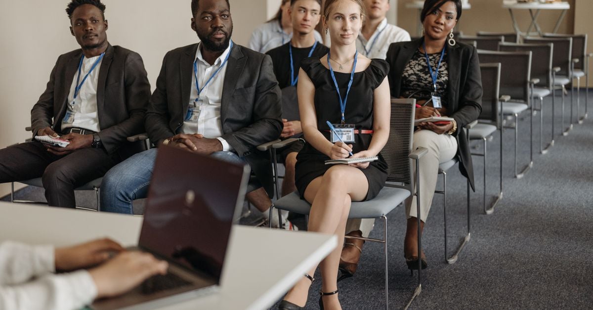 Diverse group of business professionals attentively attending a conference session.