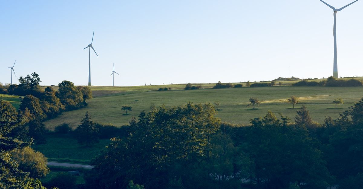 Scenic view of wind turbines on grassy hills in Luxembourg under clear blue sky.