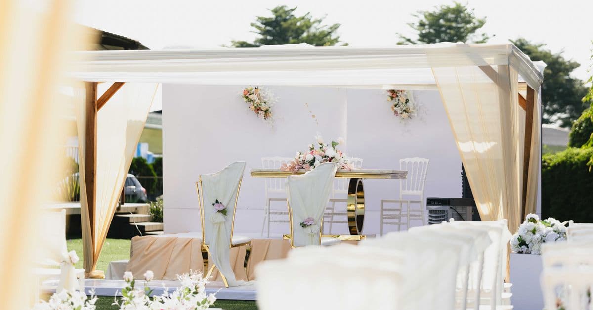 Prachtige locatie voor een buitenbruiloft met witte en pastelkleurige decoraties en bloemstukken.