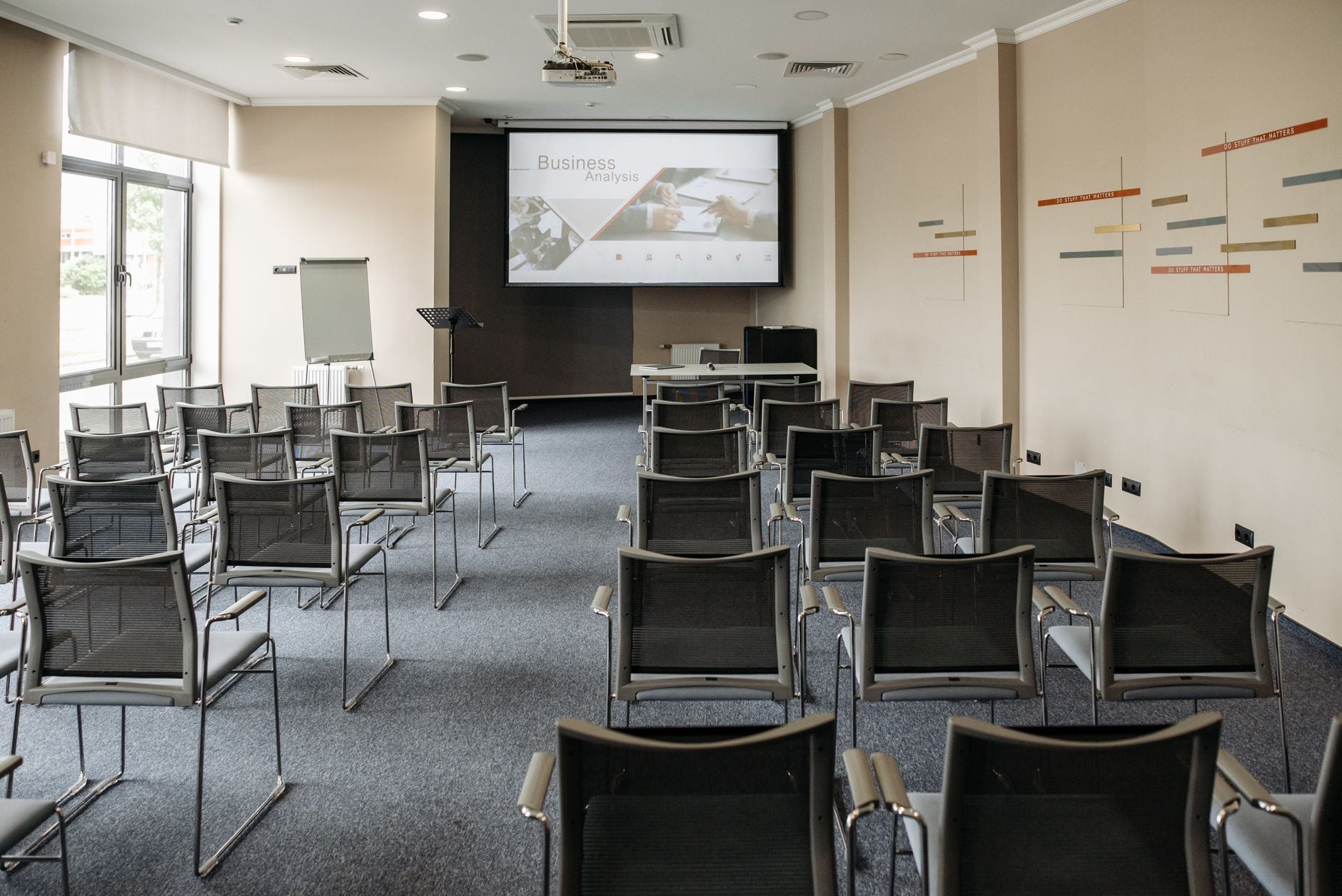Lege vergaderzaal met stoelen en een presentatiescherm voorbereid voor zakelijke vergaderingen.
