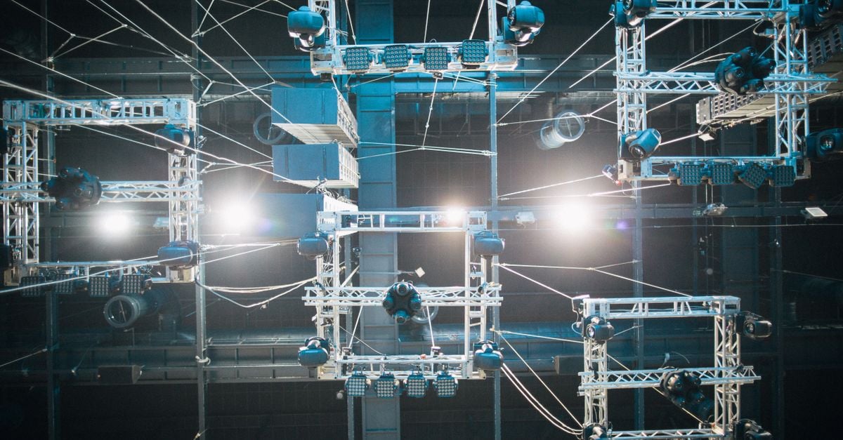 Top view of digital screen under ropes and metal constructions illuminated by shiny lights on stage