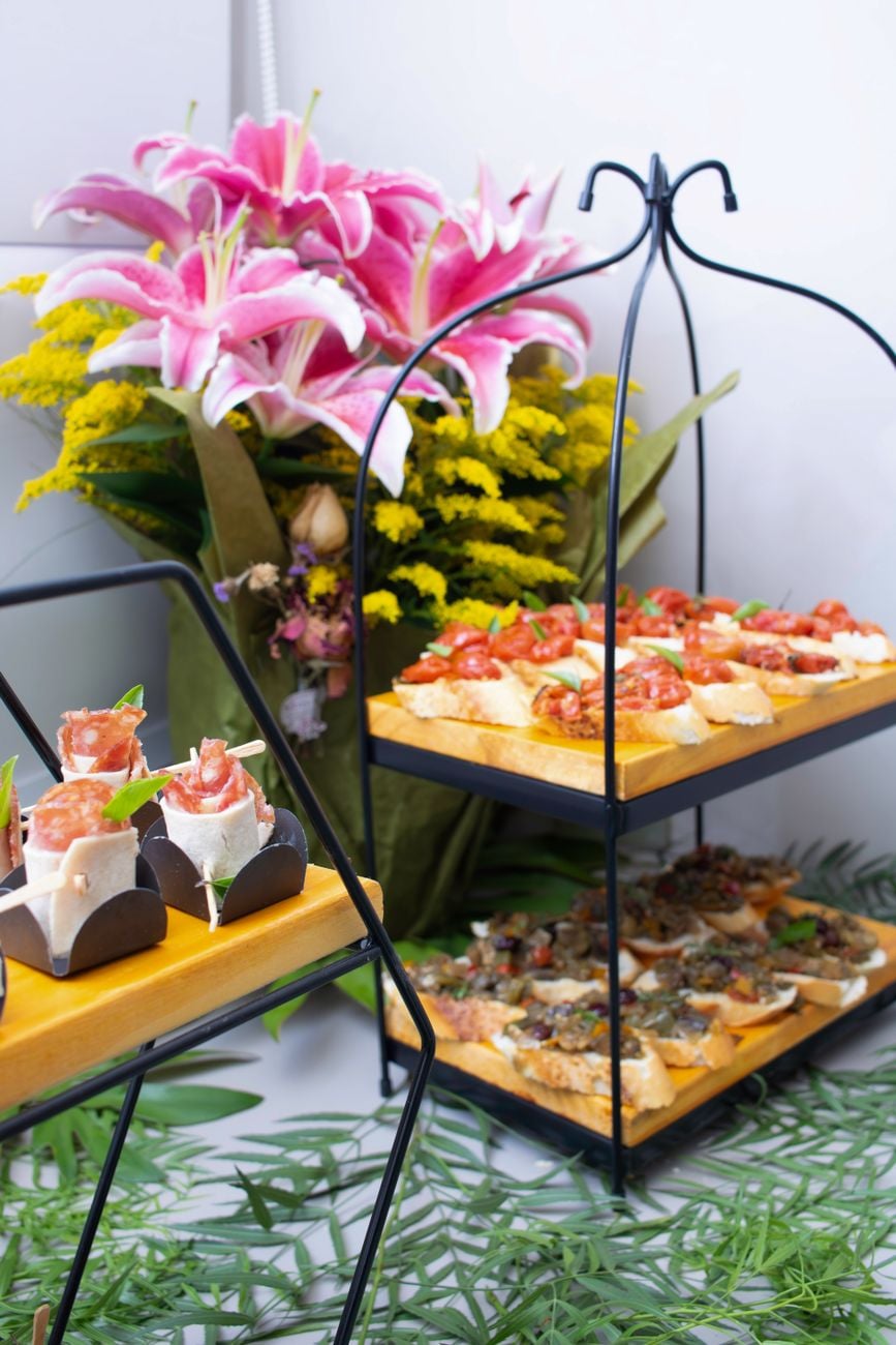 Chique cateringopstelling met gourmet hapjes en levendige bloemdecoraties, perfect voor evenementen.