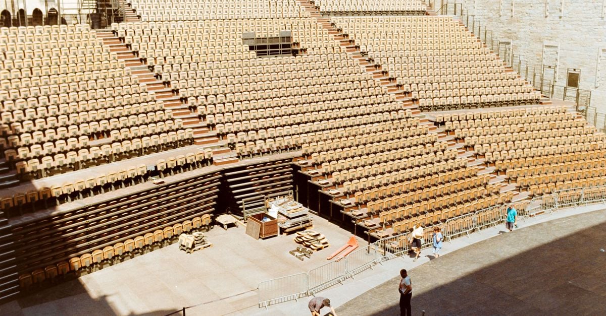 Preparations in the empty outdoor theater in Avignon, France, during daylight.