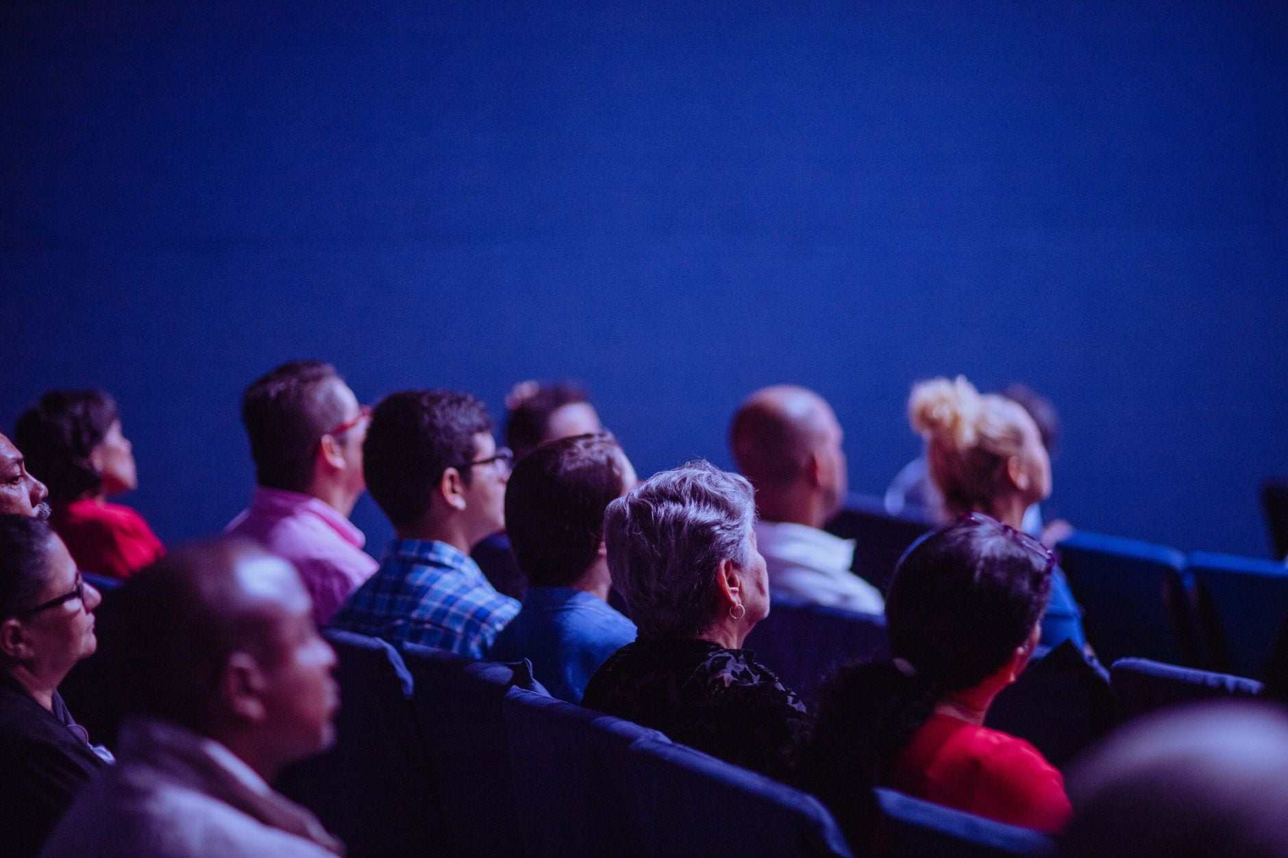 Een aandachtige groep volwassenen die zit in een interne conferentie en zich concentreert op een presentatie.