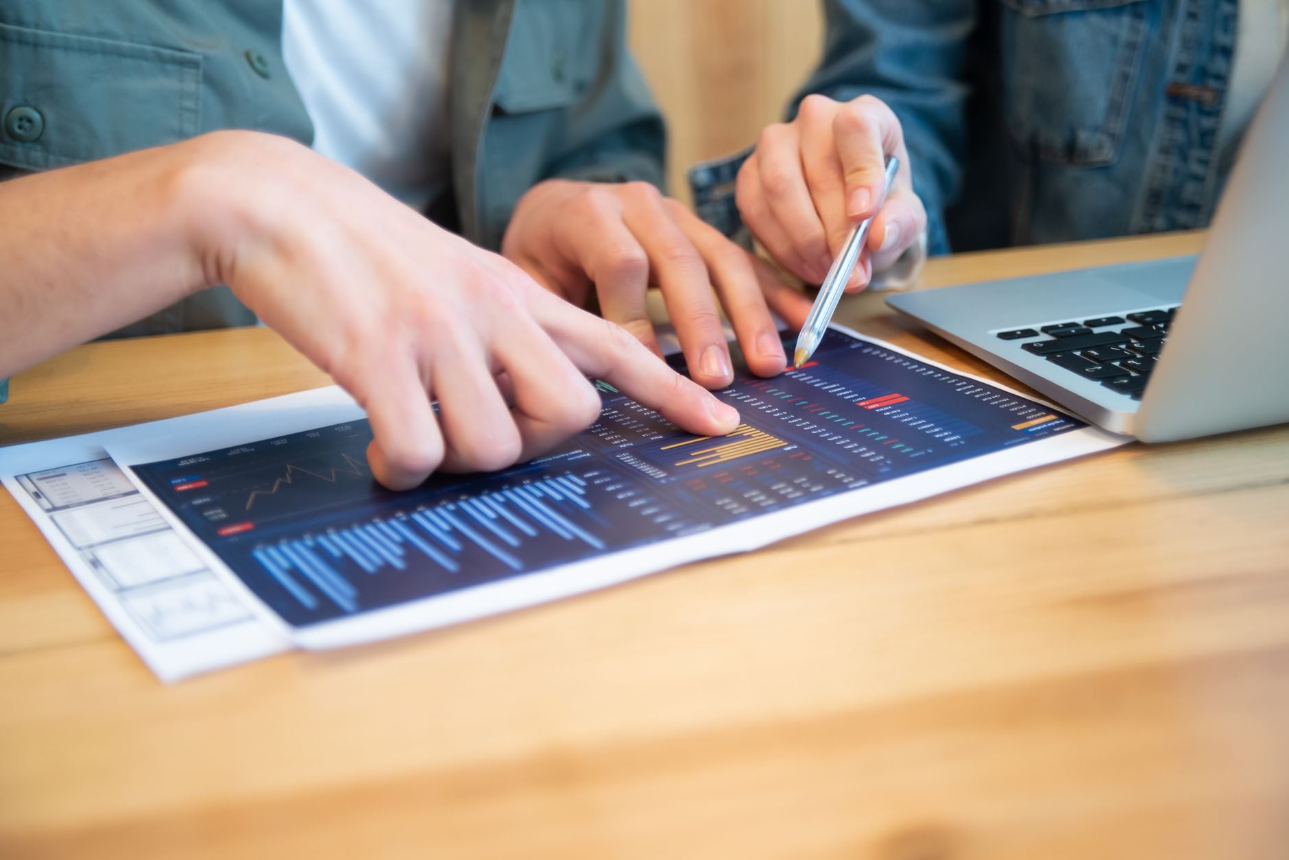 Samenwerkingsdiscussie over datagraphieken en laptop, gericht op bedrijfsstrategieën.