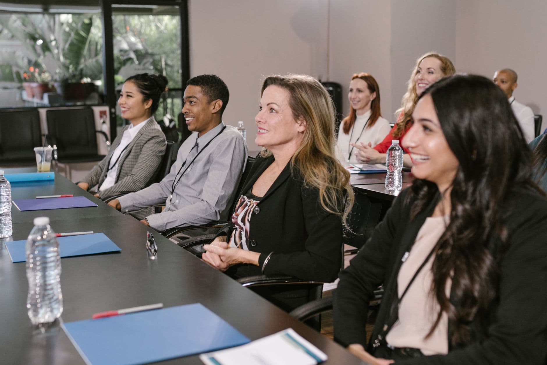 Een diverse groep die een seminar bijwoont in een professionele setting, gefocust en betrokken.
