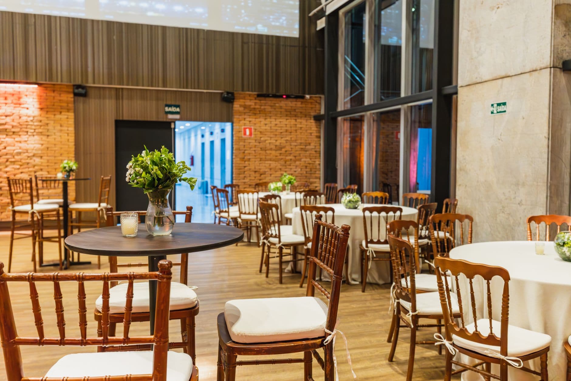 Prachtig versierde hal met houten stoelen en tafels, perfect voor feesten en evenementen.