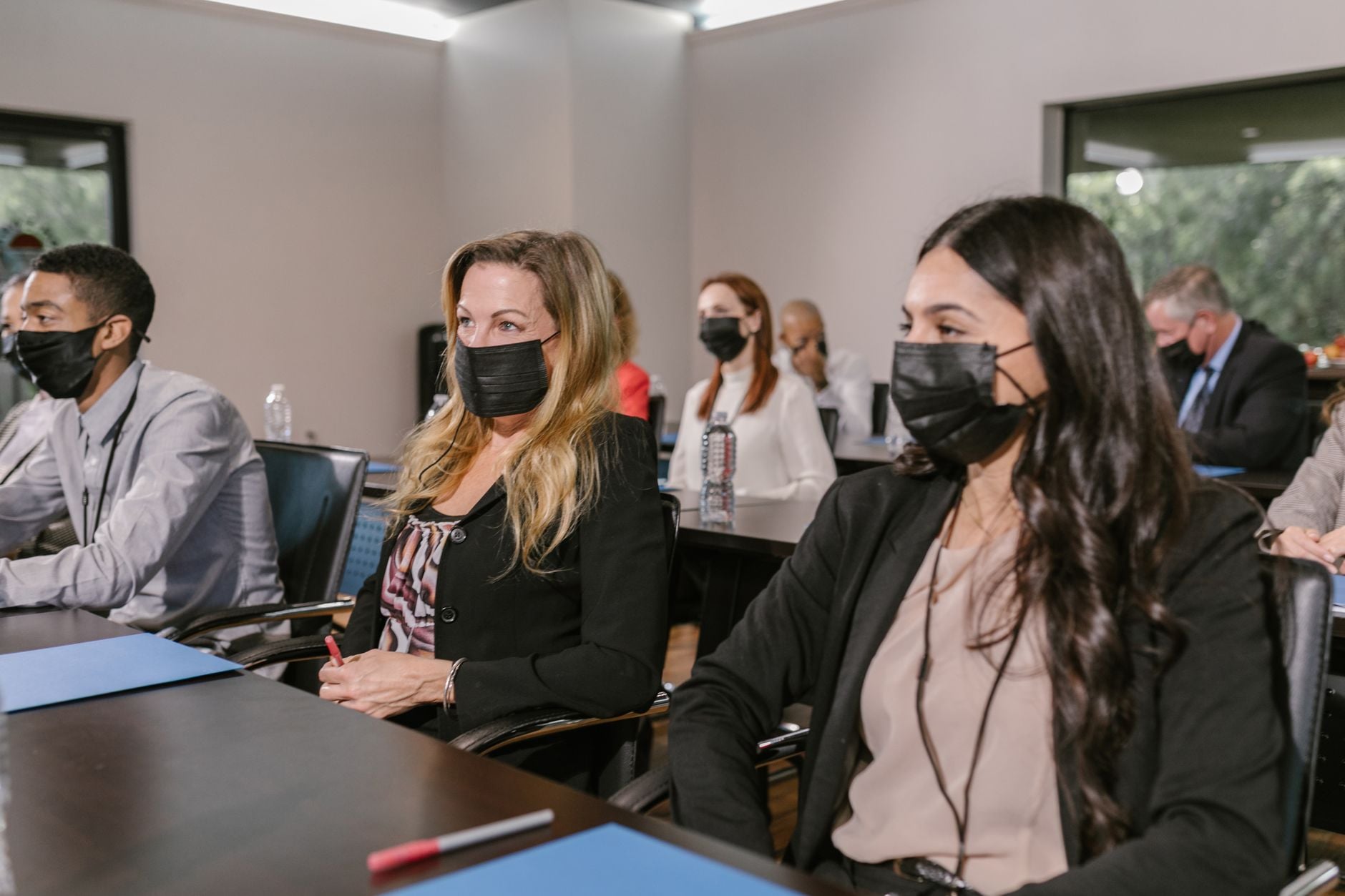 Een professionele seminar met volwassenen die mondmaskers dragen, met nadruk op pandemiepreventie.