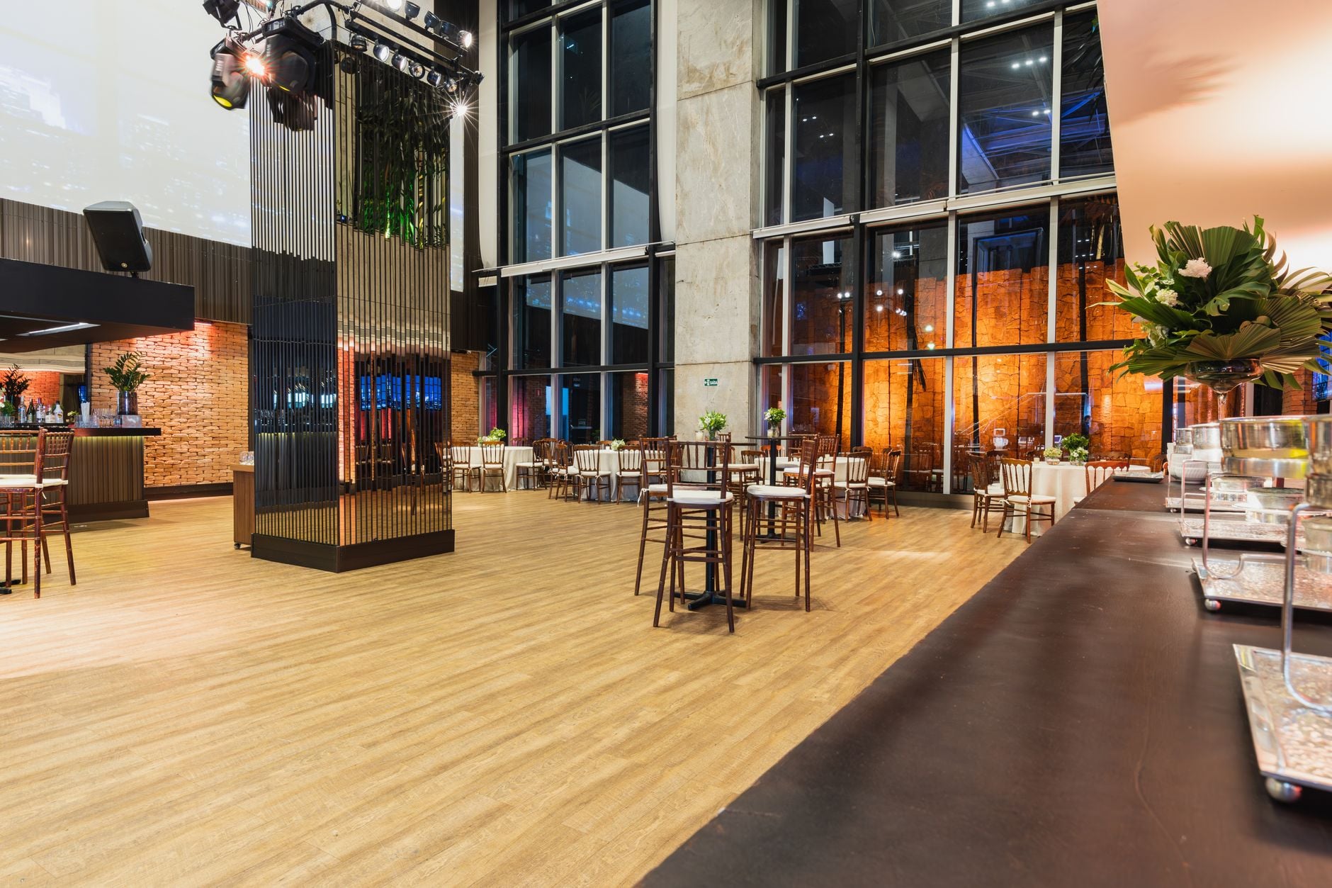 Een moderne en stijlvolle evenementenzaal, klaar voor een diner of viering, met grote ramen en hedendaagse decoratie.