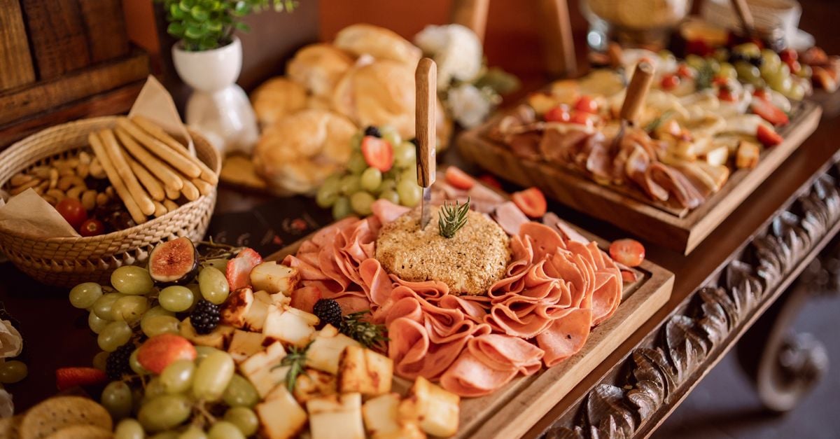 Delightful charcuterie board with meats, cheeses, and fresh fruits at an event setup.