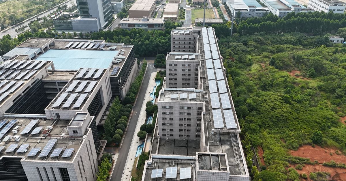 Aerial urban landscape with solar-panel rooftops and green spaces.