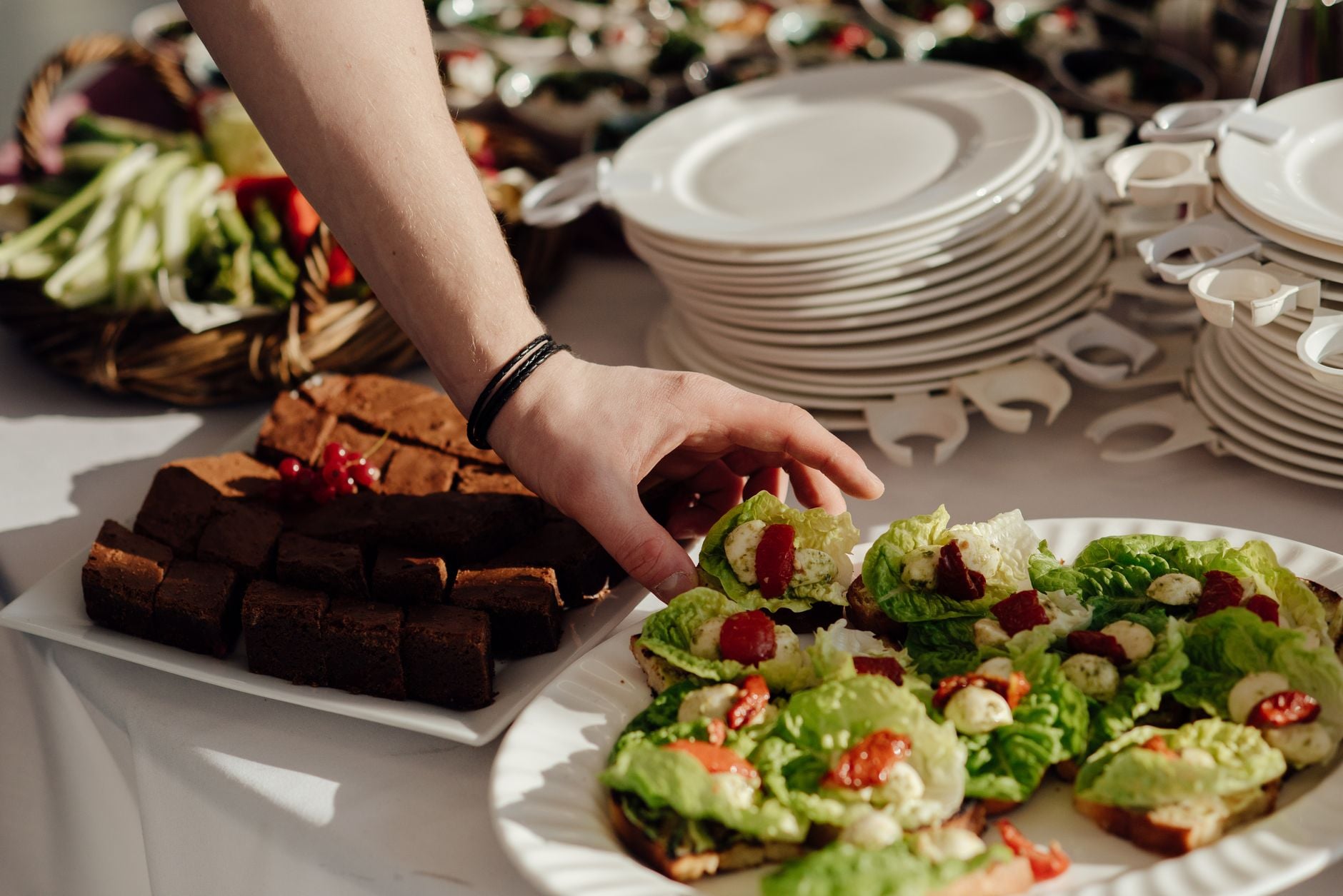 Een buffetopstelling met verse salades en brownies, klaar om te serveren op een goed gedekte tafel.