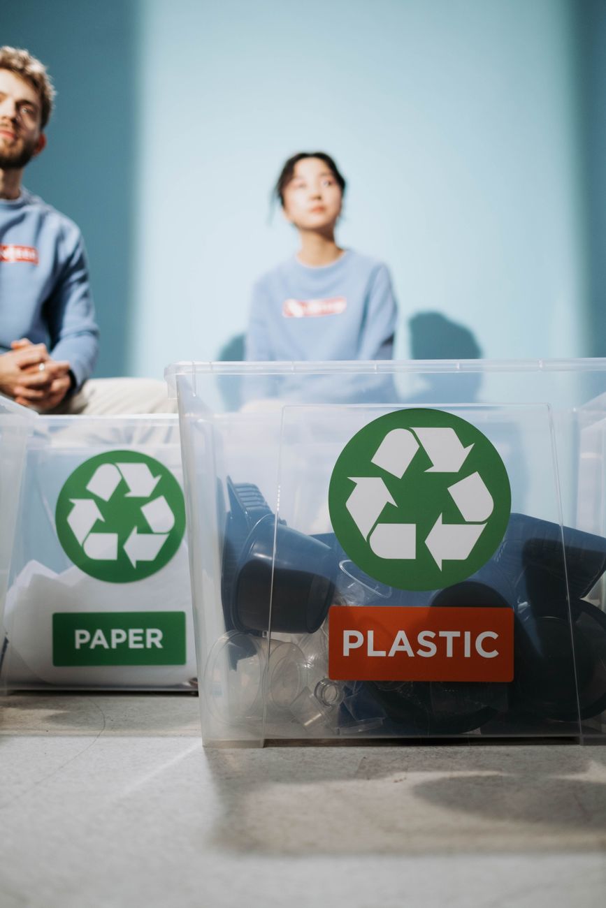 Twee recyclebakken gelabeld voor papier en plastic materialen voor milieubehoud.
