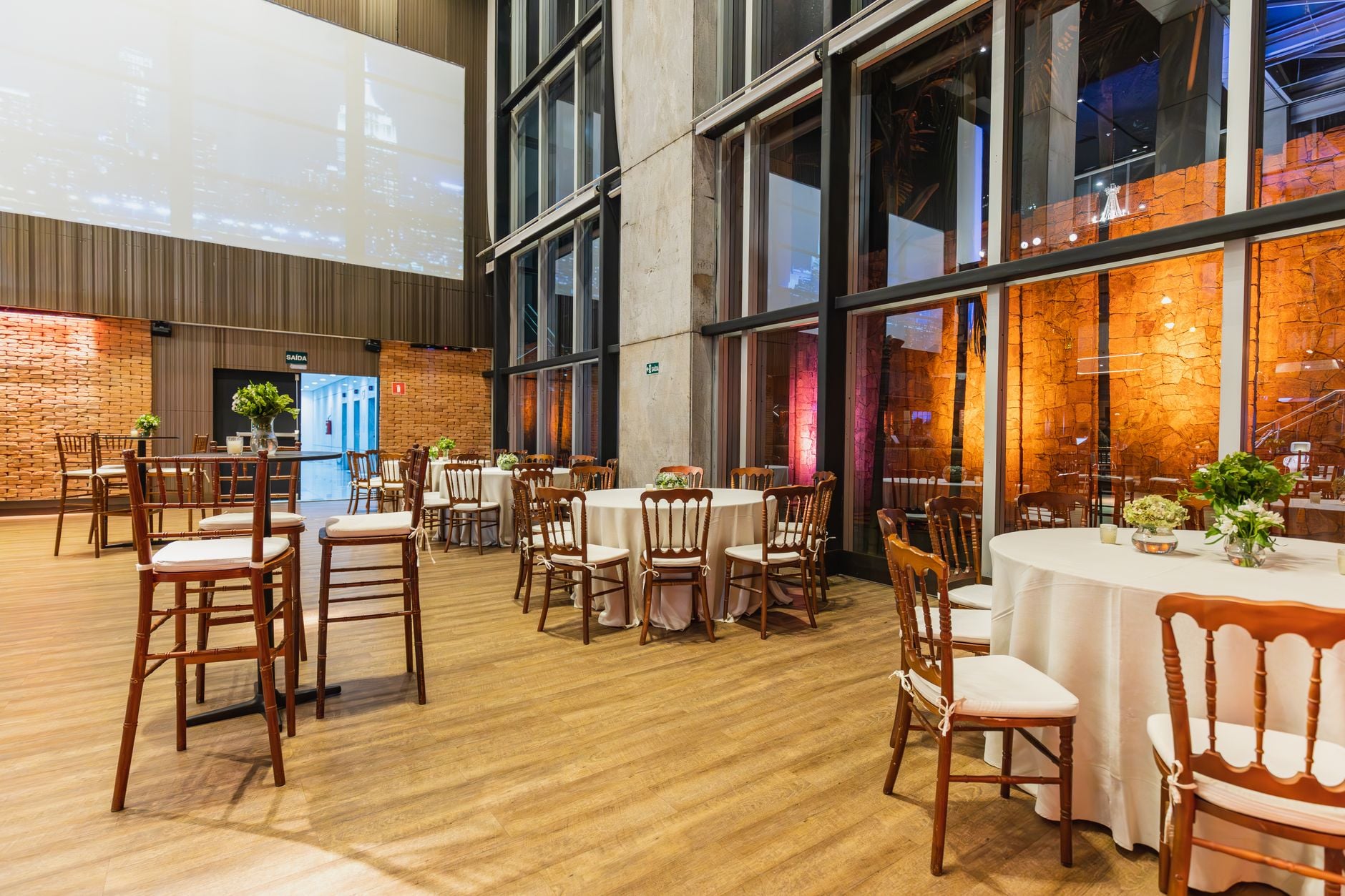 Stijlvolle binnenlocatie met elegante ronde tafels en stoelen, perfect voor vieringen.