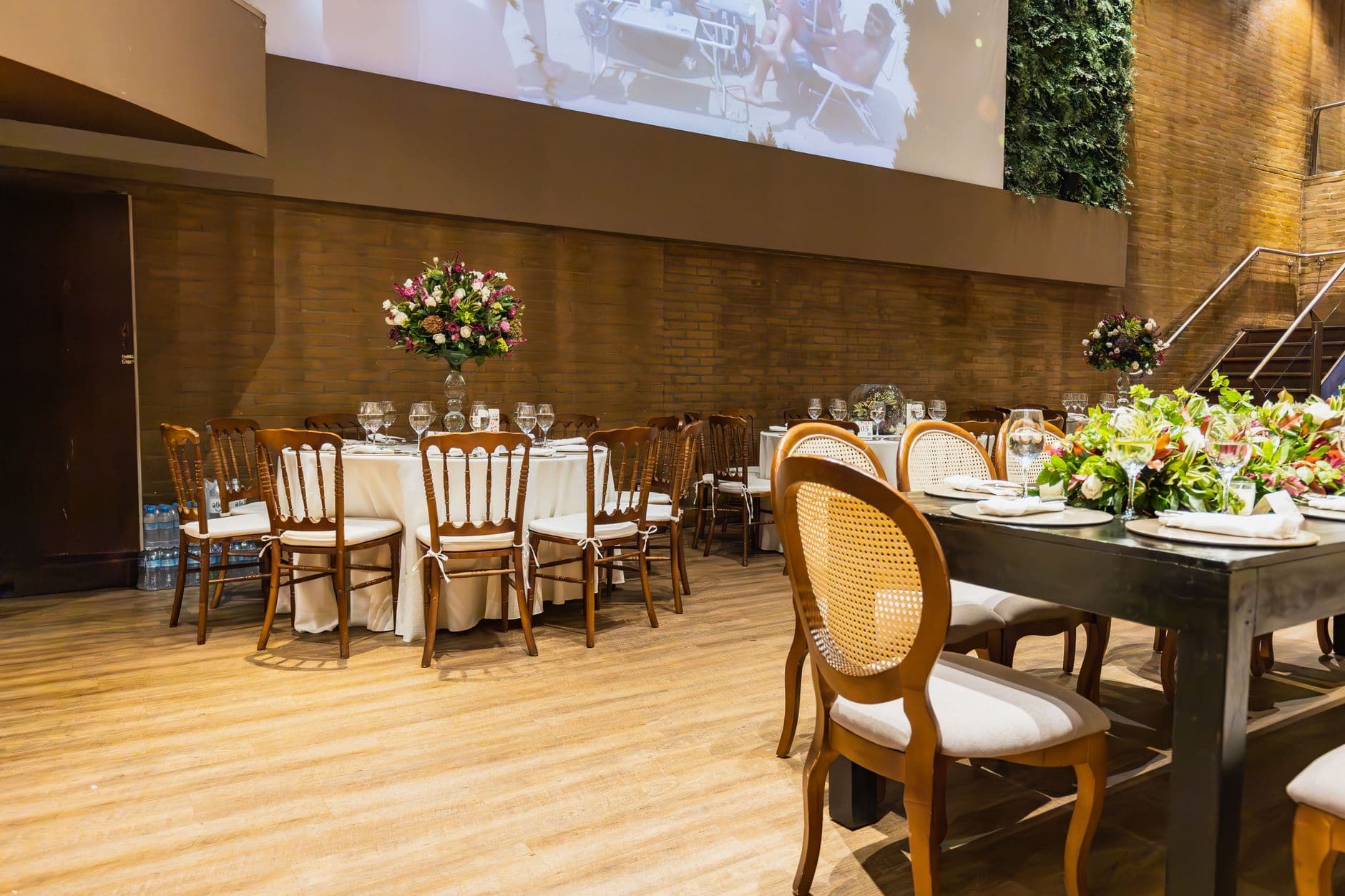 Luxe binnenbruiloft met bloemstukken en elegant gedekte tafels.