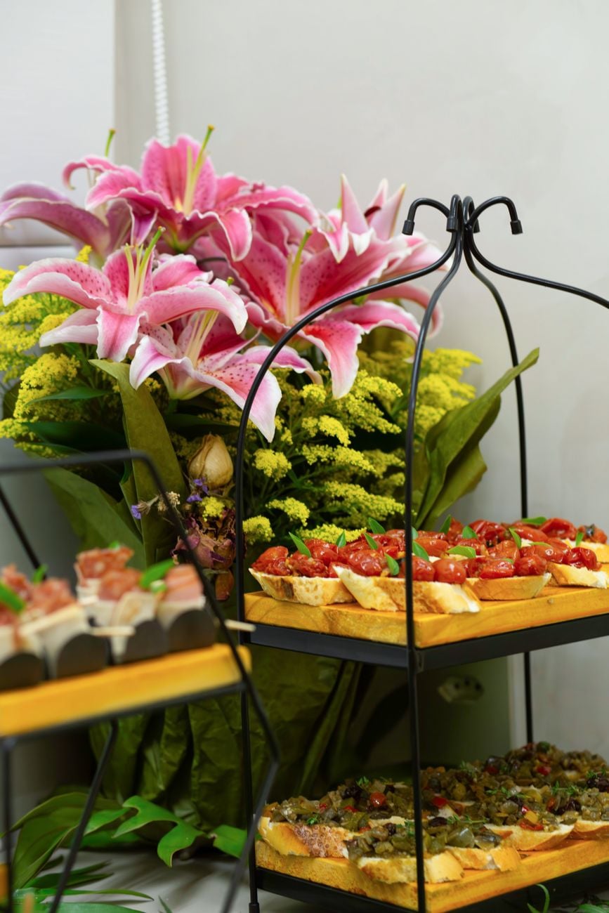 Een stijlvolle cateringpresentatie met voorgerechten en een levendige bloemarrangement.