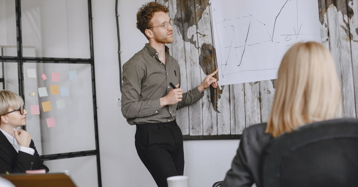 A group of professionals engaged in a business meeting with a presentation in a modern office.