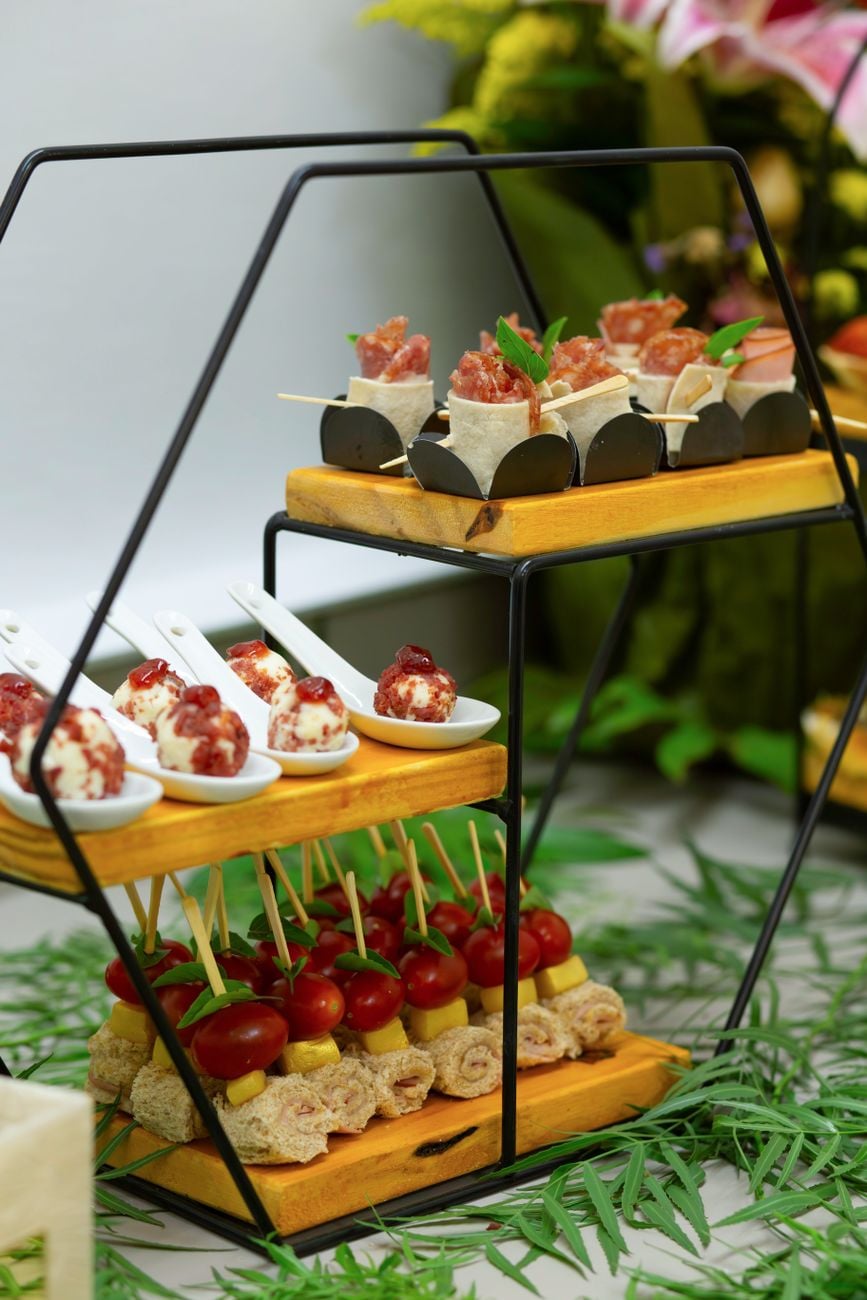 Prachtig gerangschikte gastronomische hapjes op een stijlvolle cateringstand, perfect voor evenementen.