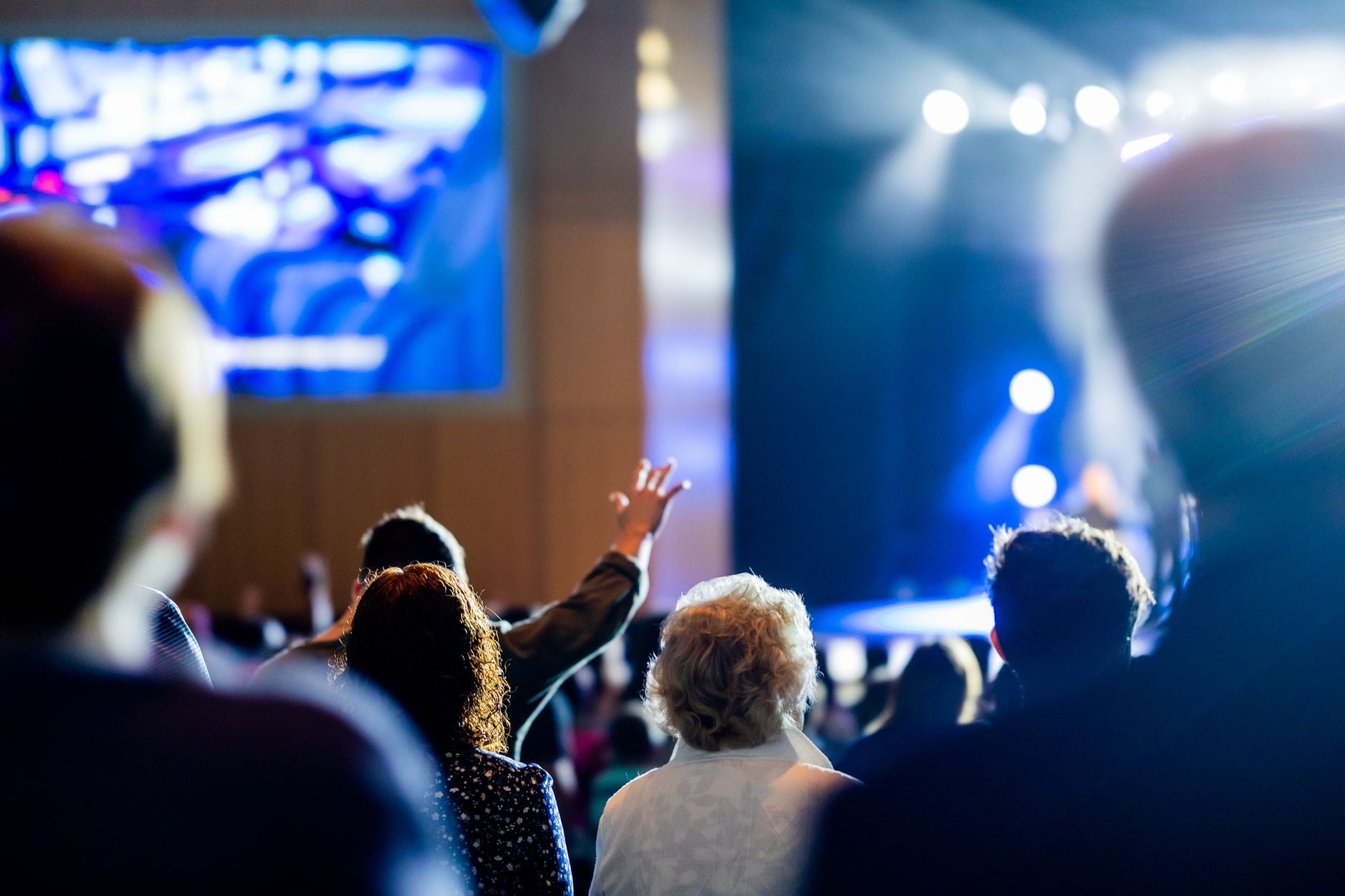 Levendige concertscène met een levendig publiek en kleurrijke podiumverlichting.