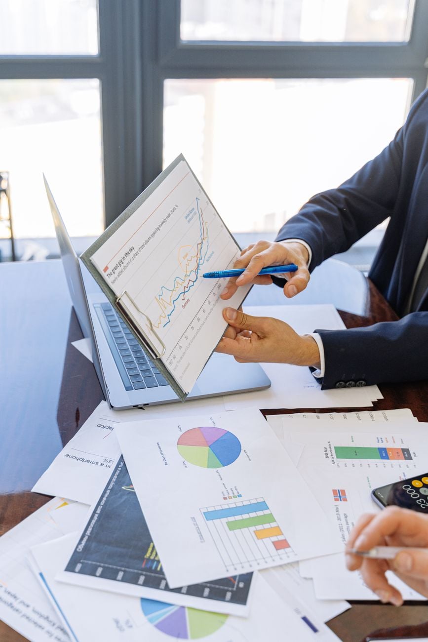 Zakelijke professionals bespreken financiële grafieken en diagrammen in een kantooromgeving.